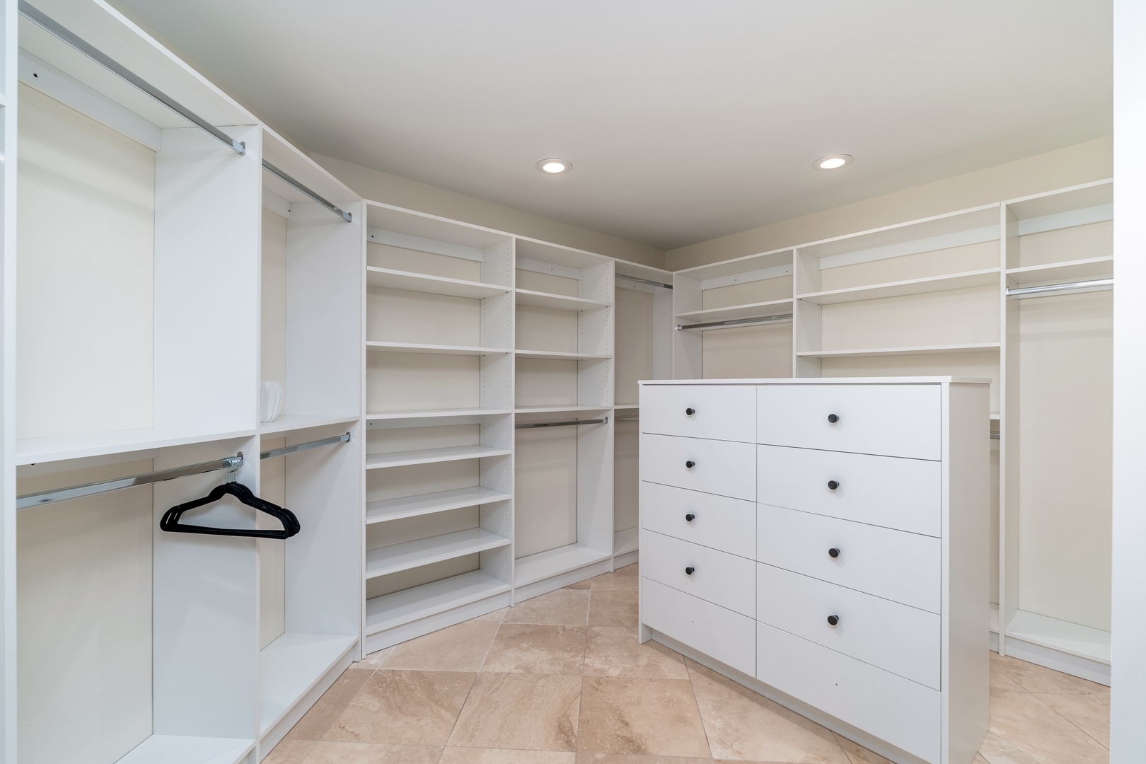 Step into your spacious walk-in closet with custom shelving, built-in drawers, and multiple hanging rods to keep all your belongings perfectly organized throughout your stay.