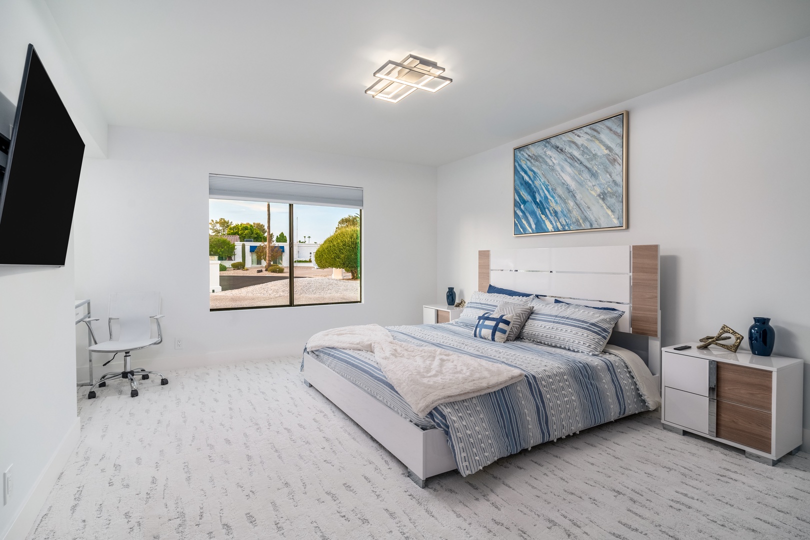 Sink into plush comfort after a day of exploring. This bright bedroom invites restful nights with its modern design, soft bedding, and peaceful view of the landscaped grounds.