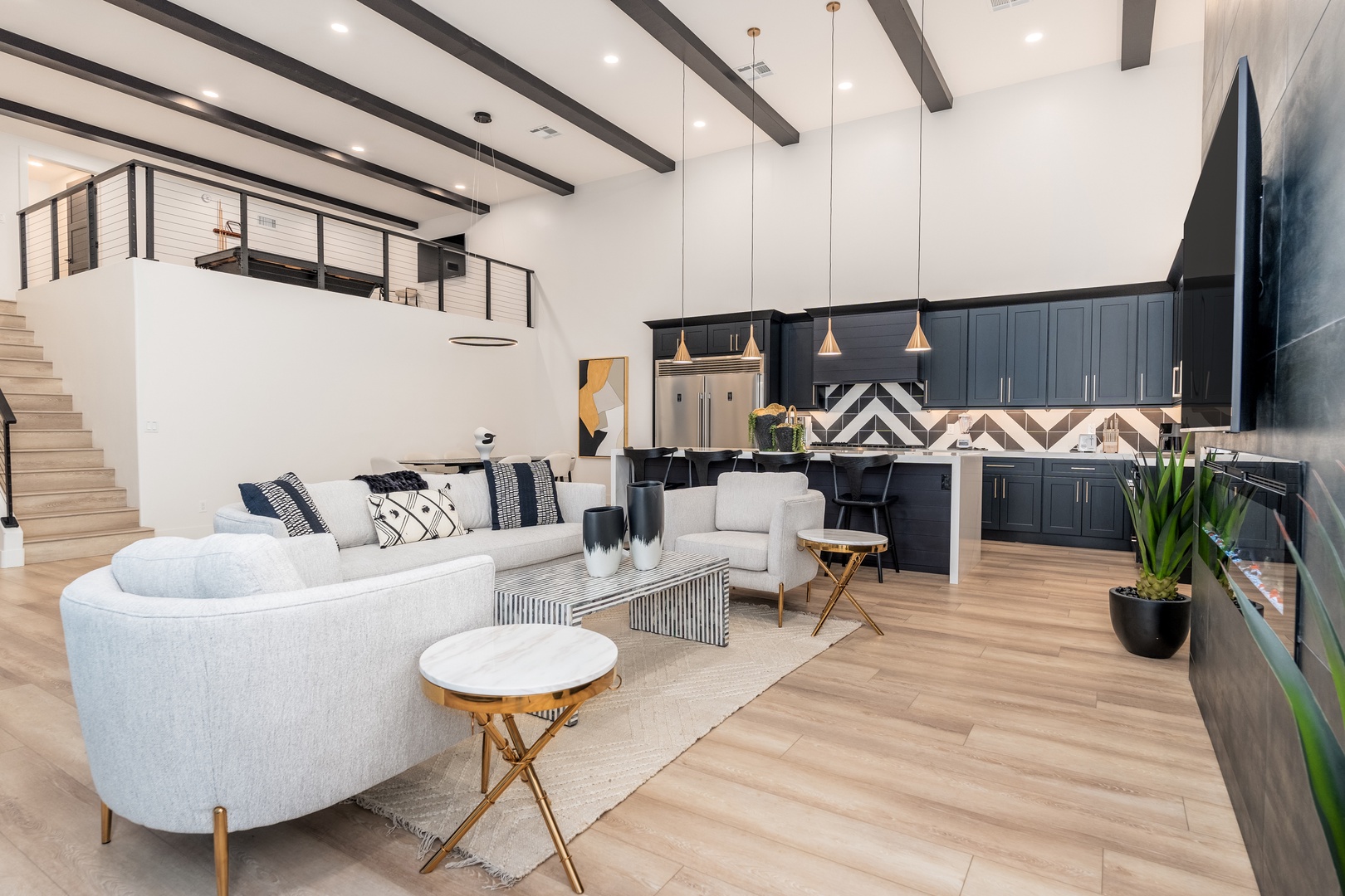 Step into your open-concept sanctuary where modern elegance meets comfort. Soaring ceilings with dramatic beams and designer lighting create a welcoming space to unwind after your adventures.