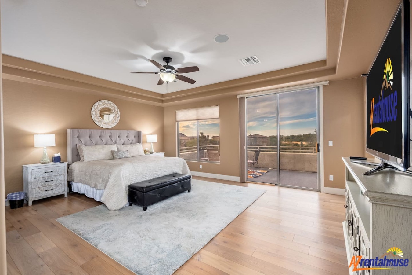 Unwind in your spacious master suite featuring elegant furnishings, a cozy ceiling fan, and stunning balcony views.