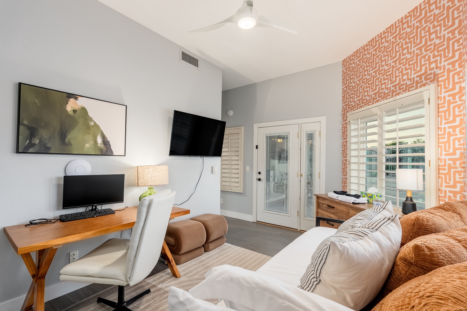 Sink into plush seating and enjoy your favorite shows on the wall-mounted TV. A dedicated workspace awaits you by the window, while the accent wall adds warmth and character to your retreat.