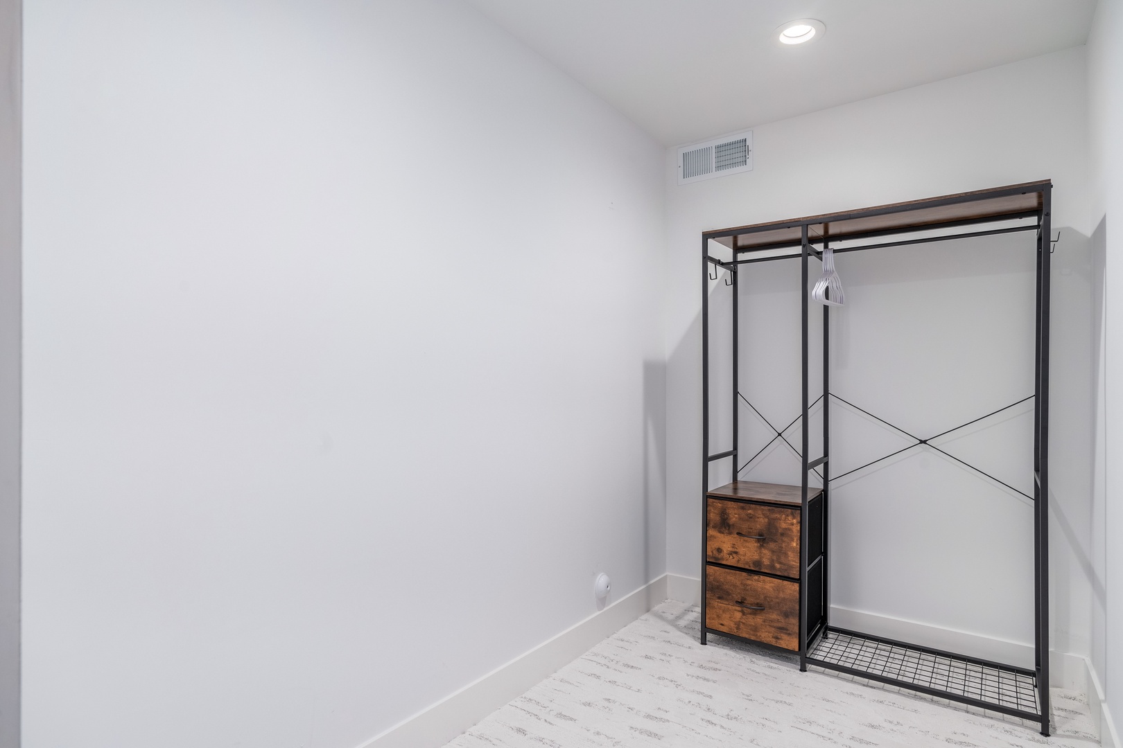 Your spacious walk-in closet offers plenty of room for your wardrobe, with a stylish open rack and built-in drawers keeping your belongings organized and accessible.