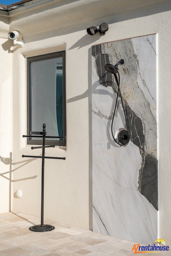 Step into your private outdoor shower with stunning marble walls and modern fixtures for a luxurious refreshing experience.