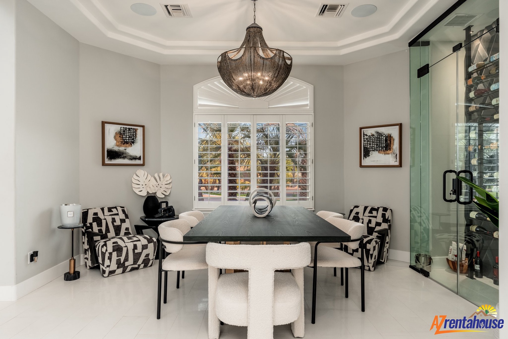 Gather around this elegant dining table beneath a stunning chandelier, where memorable meals unfold in sophisticated comfort.