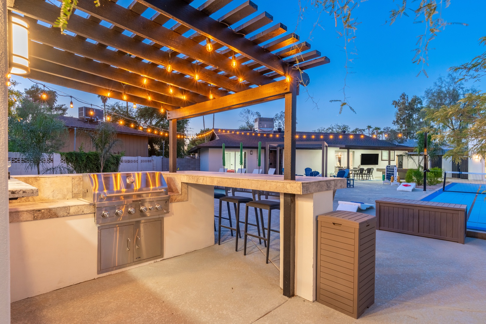 Your private outdoor paradise awaits with a custom grill station, bar seating under twinkling lights, and a spa steps away—perfect for sunset gatherings and starlit relaxation.
