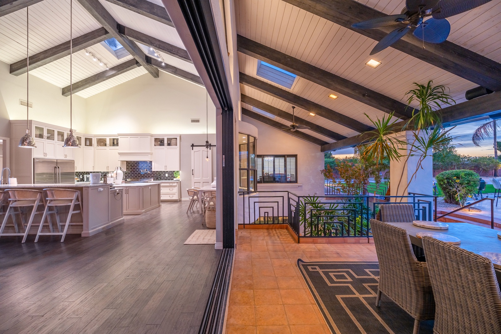 Step into your open-concept retreat where soaring vaulted ceilings and skylights flood the space with natural light, seamlessly blending the gourmet kitchen with your private patio oasis.