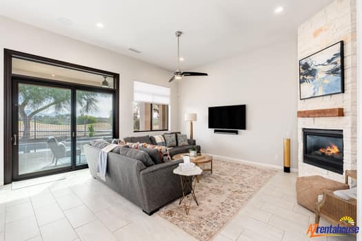 Relax in your bright, open living space with plush seating, modern fireplace, and sliding doors to outdoor views.