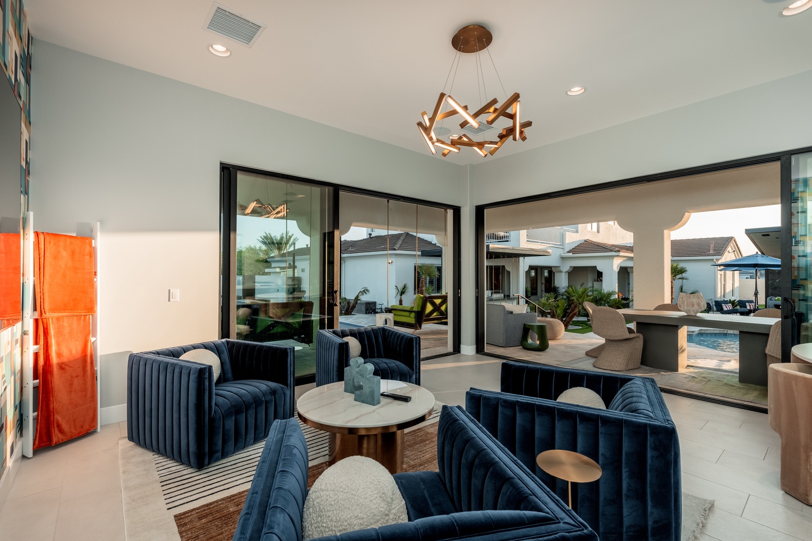 Sink into plush seating in your stylish indoor-outdoor living space, where modern design meets comfort and seamless access to the pool and patio await.