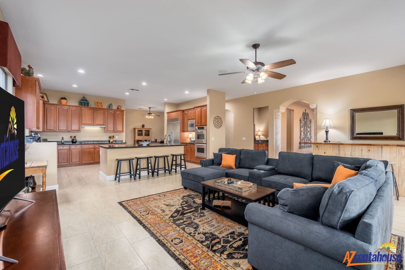 Unwind in your spacious open-concept living area featuring a comfortable sectional sofa and fully equipped kitchen with breakfast bar seating.