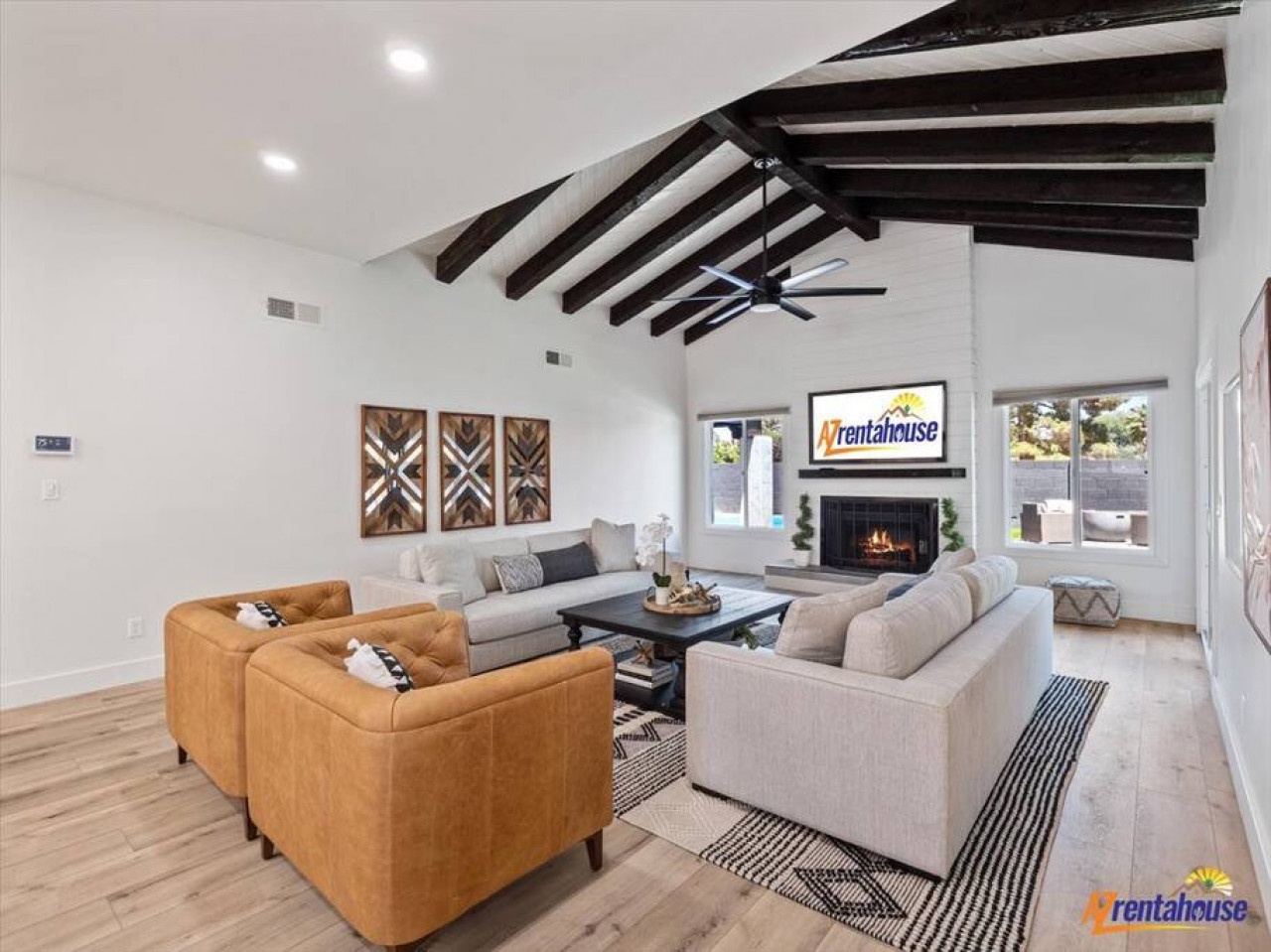 Unwind in this stunning living room where exposed beams frame your relaxation and the fireplace creates perfect ambiance for cozy evenings.