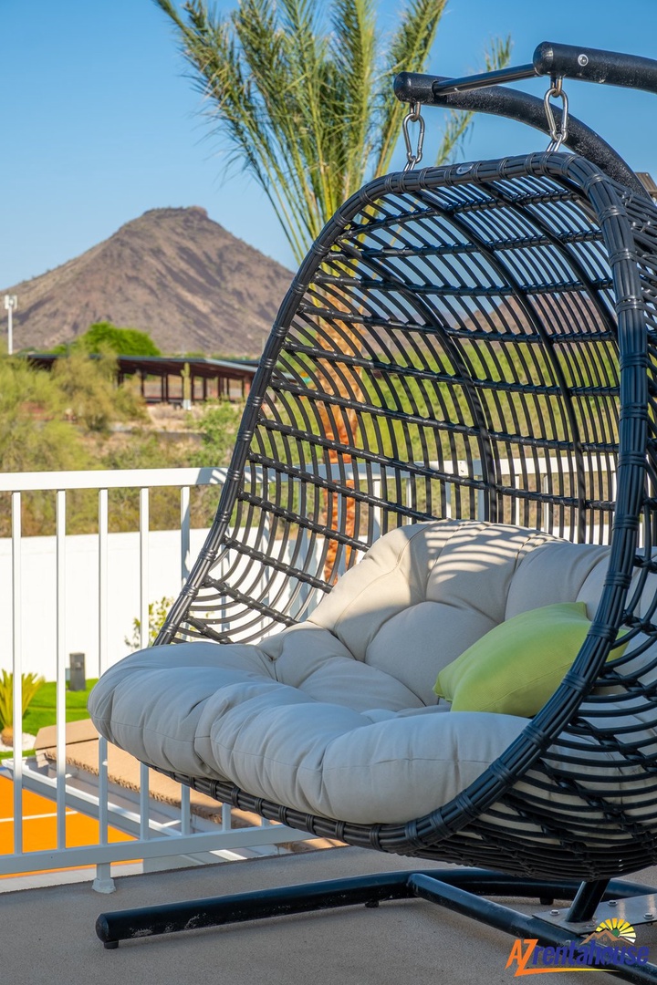 Swing into relaxation in this cozy hanging chair, your perfect spot to unwind with mountain views and desert tranquility.