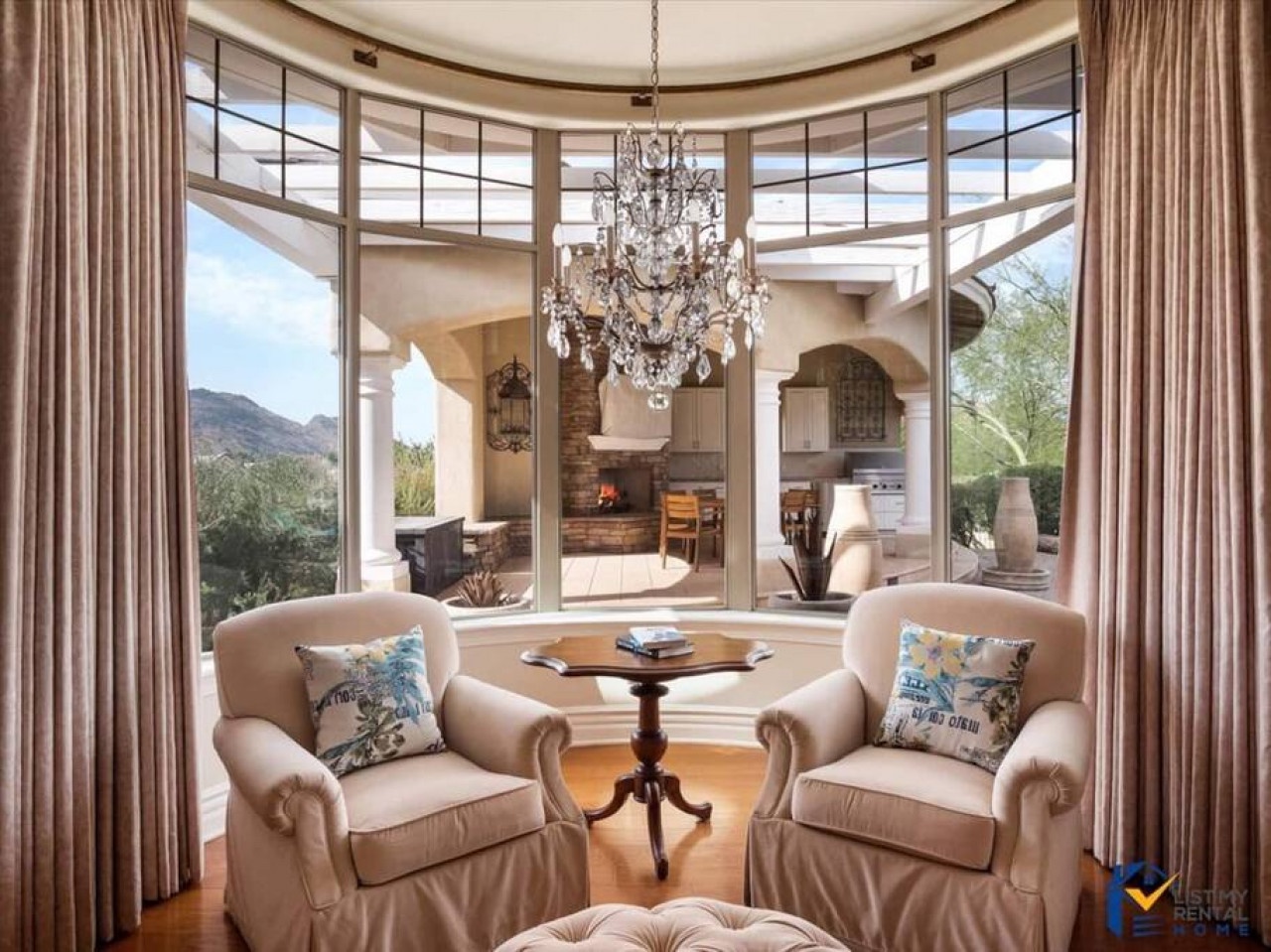 Sink into plush armchairs while gazing at mountain views through soaring windows. The crystal chandelier casts warm light across your elegant retreat.