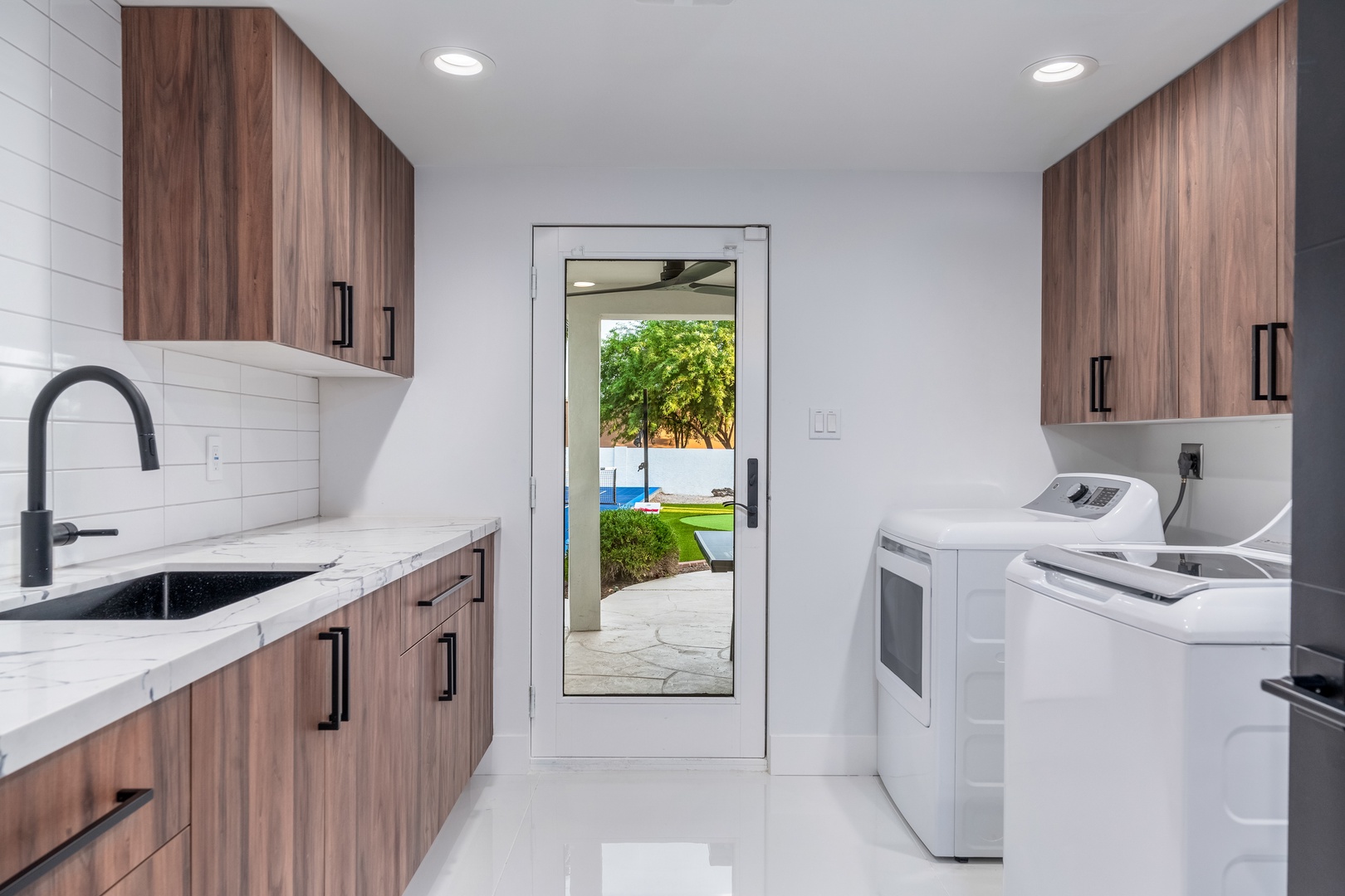 Your laundry room features a sleek modern design with a convenient sink and opens to your private outdoor oasis, making chores feel less like work and more like a breeze.