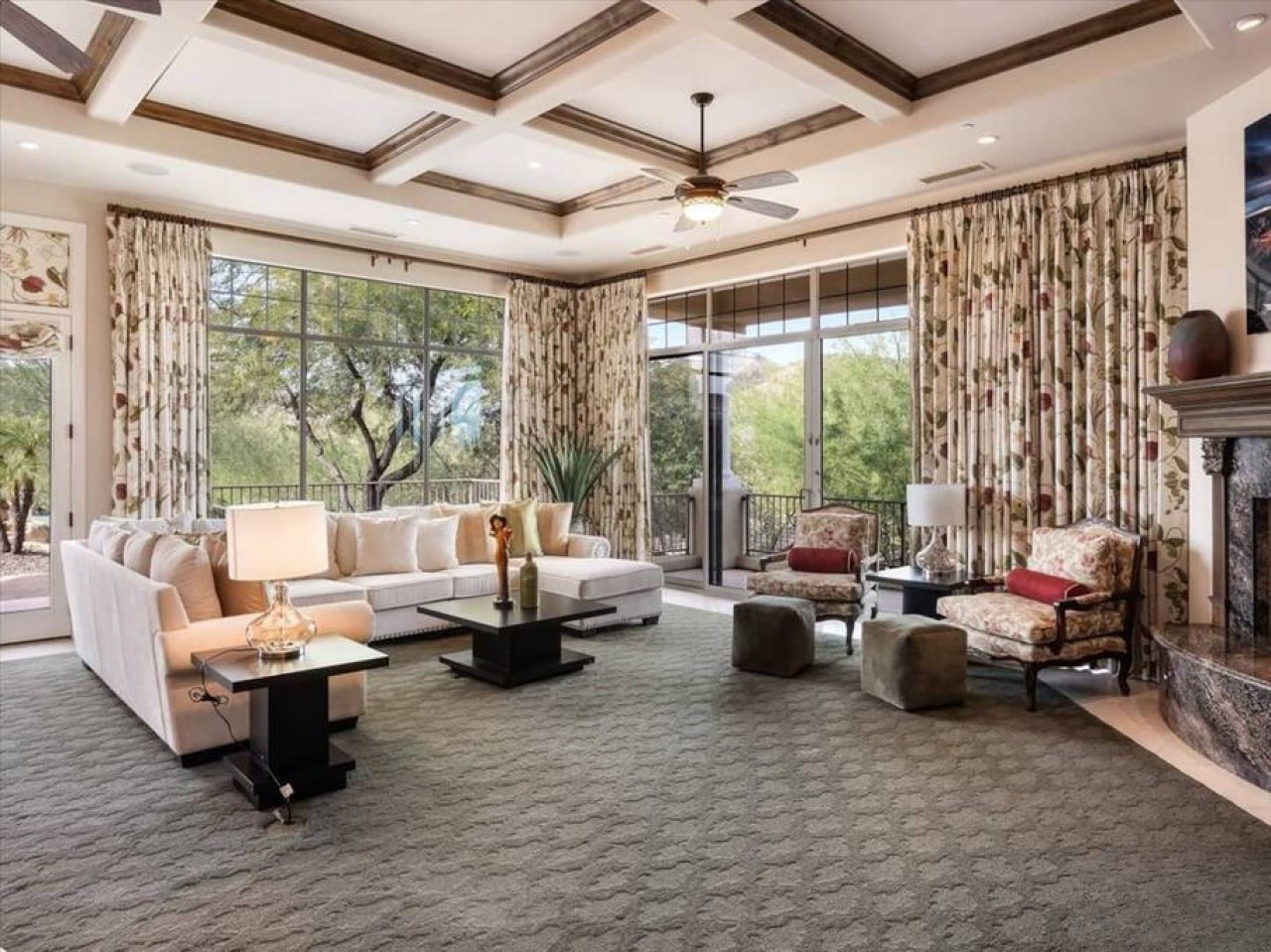 Unwind in this elegant living space with plush seating, coffered ceilings, and sweeping views of the lush desert landscape—your perfect retreat for relaxation.