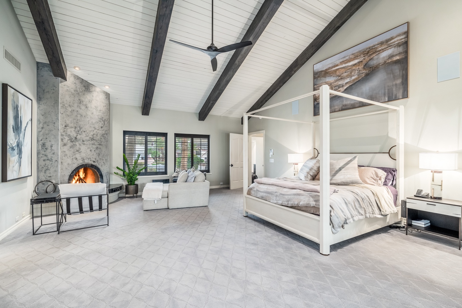 Relax in your spacious suite featuring soaring cathedral ceilings with exposed beams, a cozy fireplace, and a striking canopy bed—your personal retreat after exploring the area.