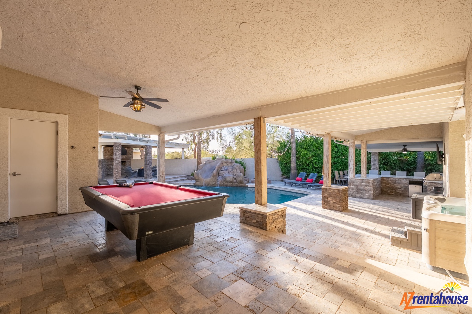 Your private covered patio invites friendly competition at the billiards table, while the sparkling pool and lounge chairs beckon just beyond, all under a desert sky.