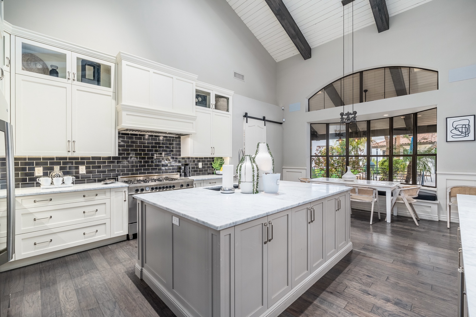 Gather around the spacious marble island in your gourmet kitchen, where soaring ceilings and sunlit windows create an inviting space for cooking and conversation.