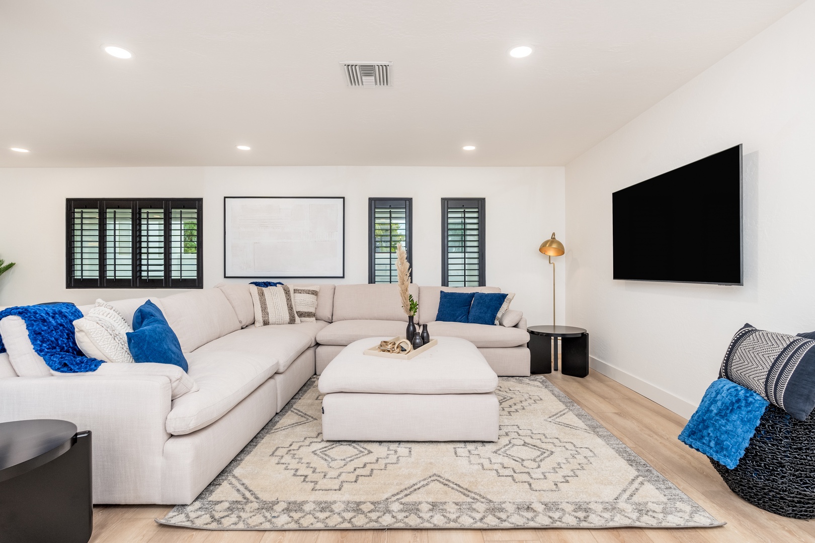 Sink into plush seating and unwind in this bright, modern living room. Enjoy your favorite shows on the large flat-screen TV while natural light filters through stylish shutters.