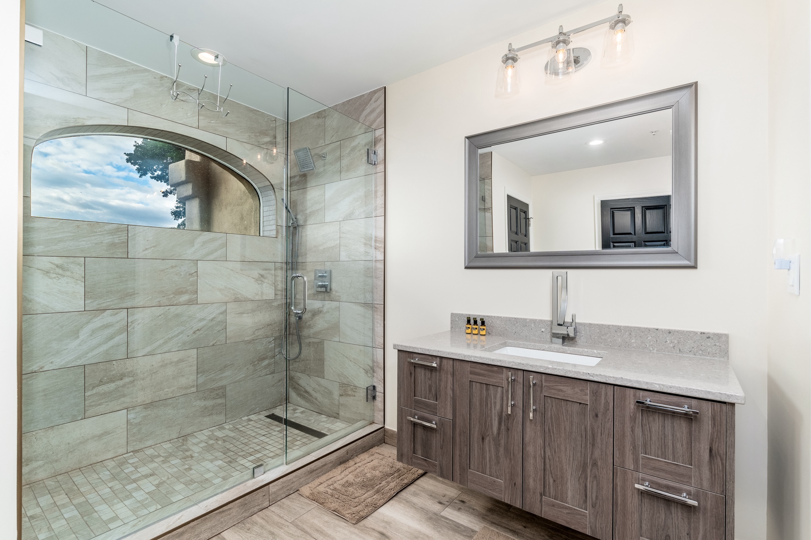 Your private spa-like bathroom features a spacious glass-enclosed shower with elegant tile work, modern fixtures, and ample vanity space for a truly relaxing retreat.