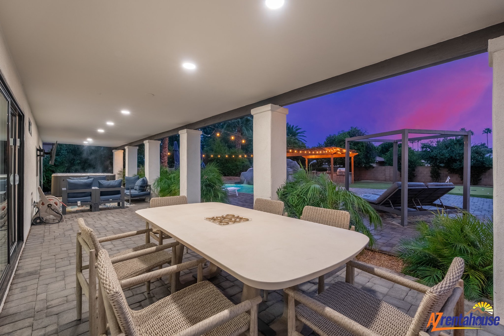 Your covered patio invites evening dining under twinkling lights, overlooking the sparkling pool and tropical garden.