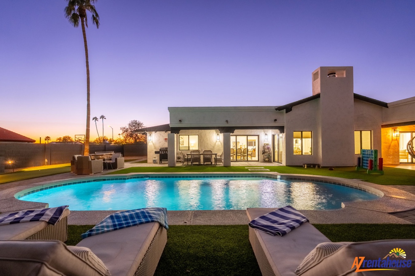 Modern desert retreat with sparkling pool and stunning twilight views, featuring covered patio perfect for evening relaxation.