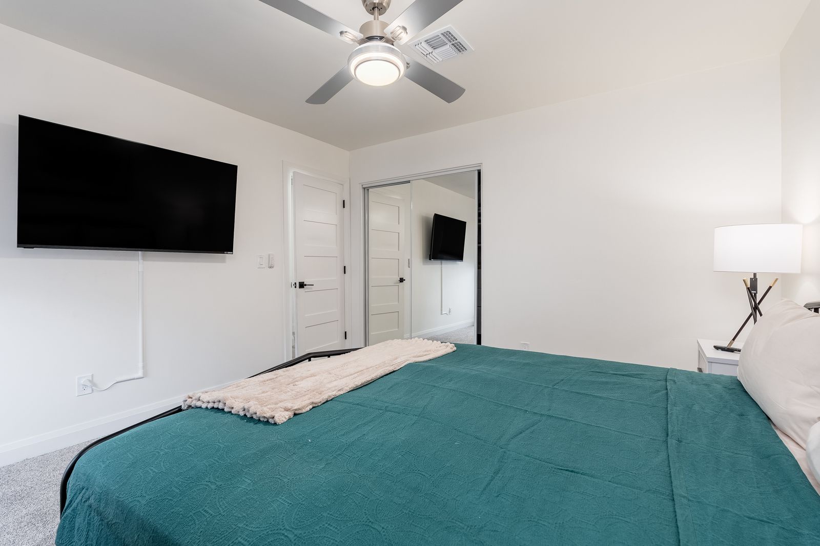 Sink into your plush bed under a cooling ceiling fan, unwind with the wall-mounted TV, and enjoy the peaceful simplicity of this bright, modern retreat.