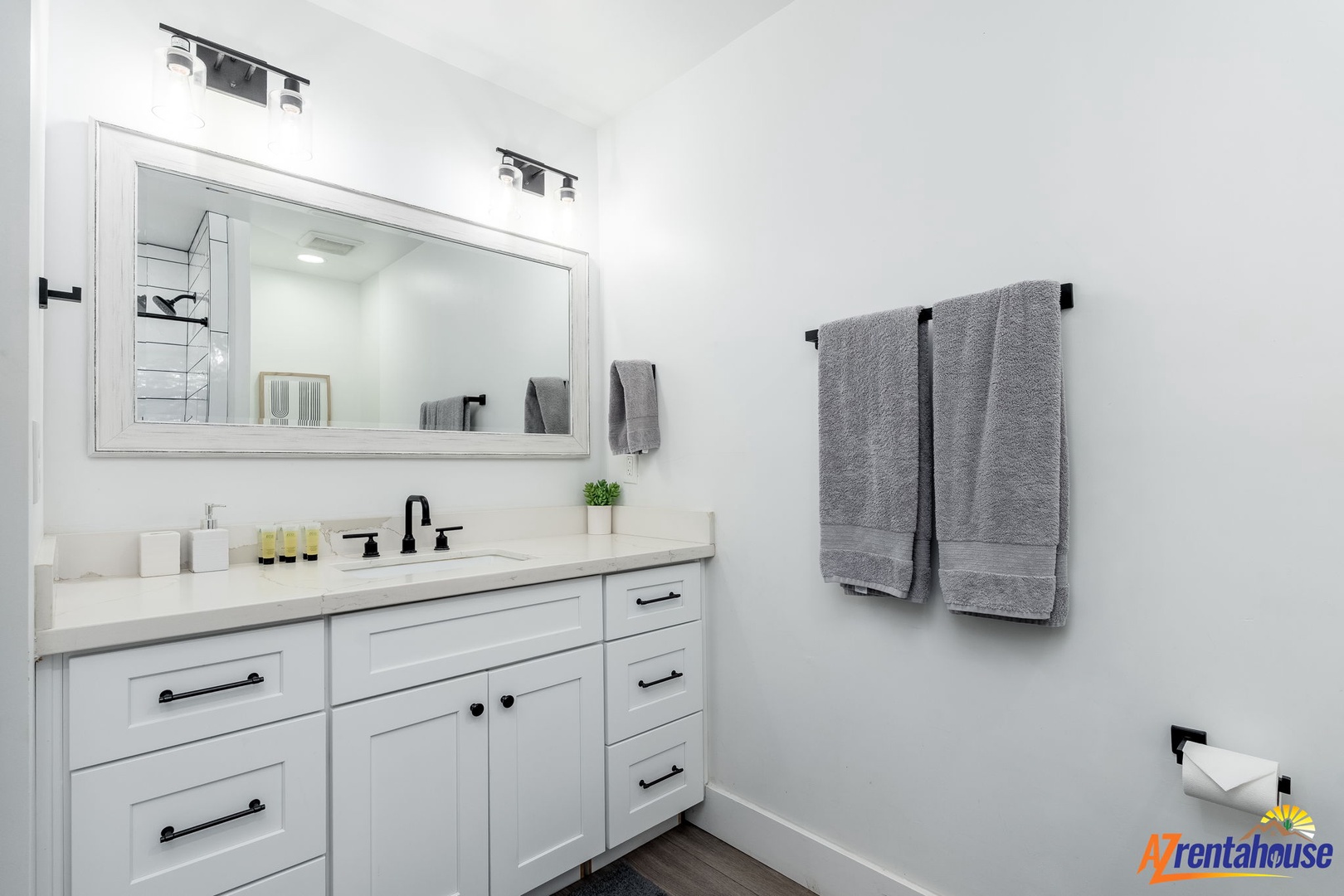 Step into your pristine bathroom with gleaming white countertops, elegant fixtures, and plush towels awaiting your arrival.