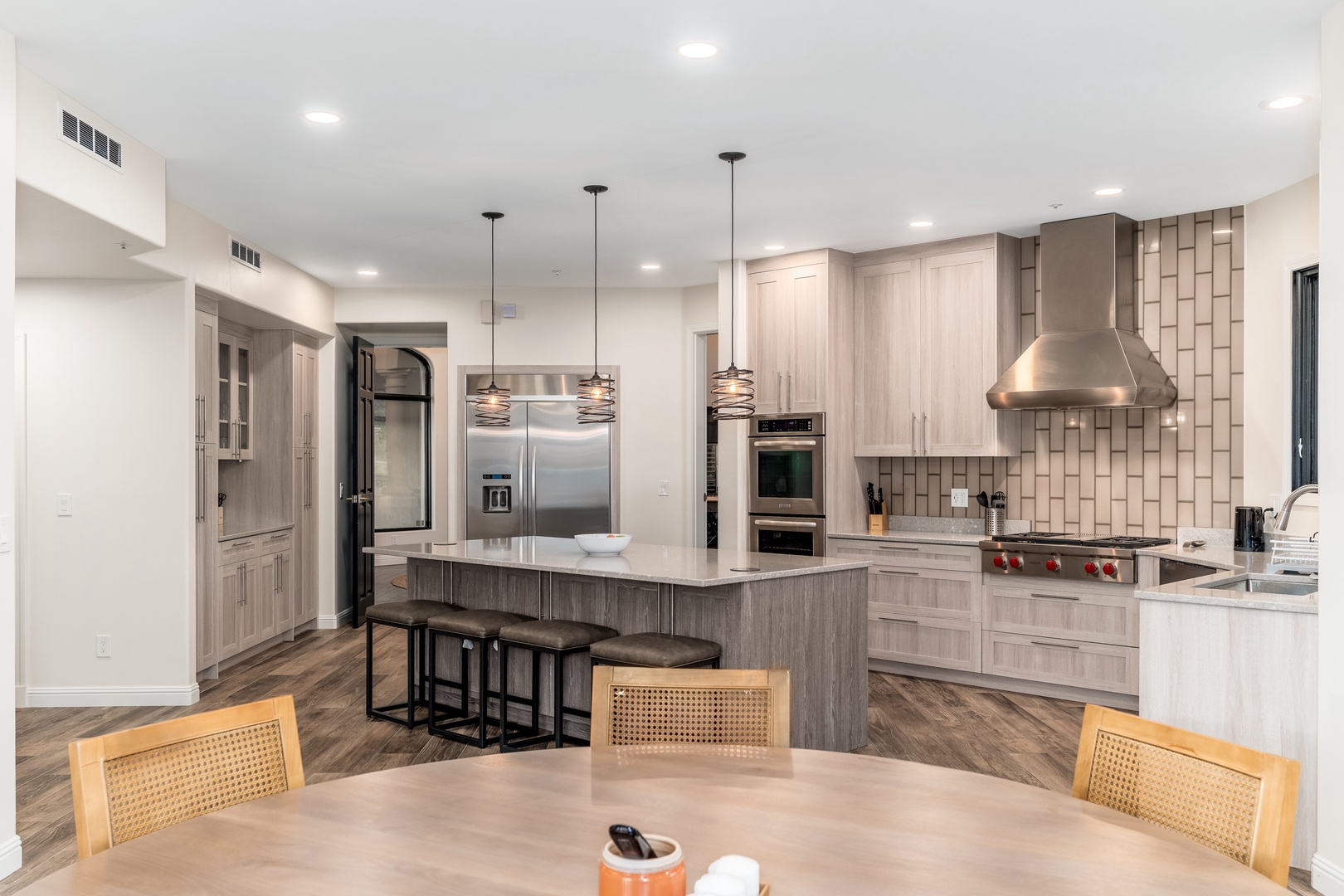 Picture yourself preparing meals in this beautifully designed gourmet kitchen, with sleek stainless appliances, a spacious island for gathering, and elegant pendant lighting creating the perfect ambiance.