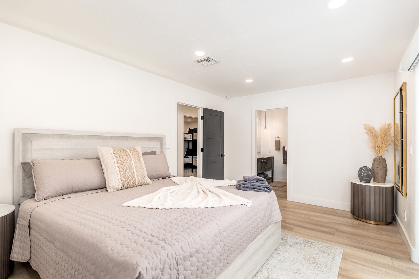 Your tranquil bedroom sanctuary features a plush bed with soft linens, sleek modern furnishings, and an ensuite bathroom—your personal retreat after a day of exploration.