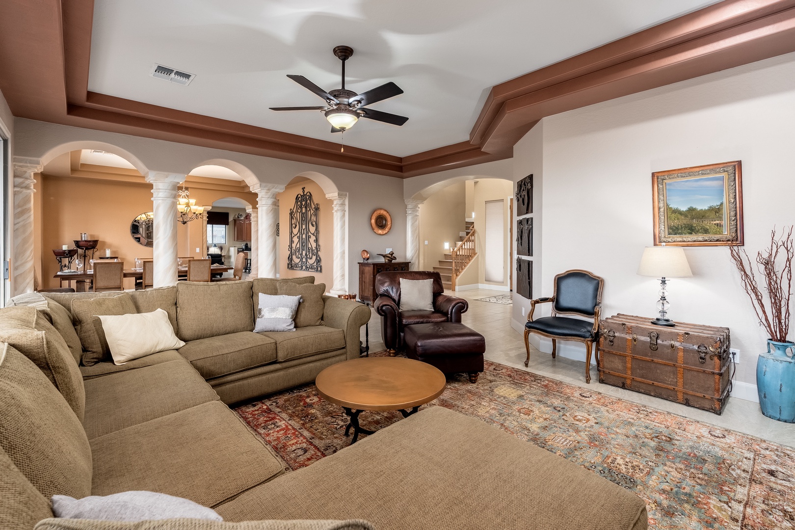 Settle into this elegant living room, where soaring ceilings, classic architectural details, and plush seating create a refined space for your group to unwind together after exploring the area.