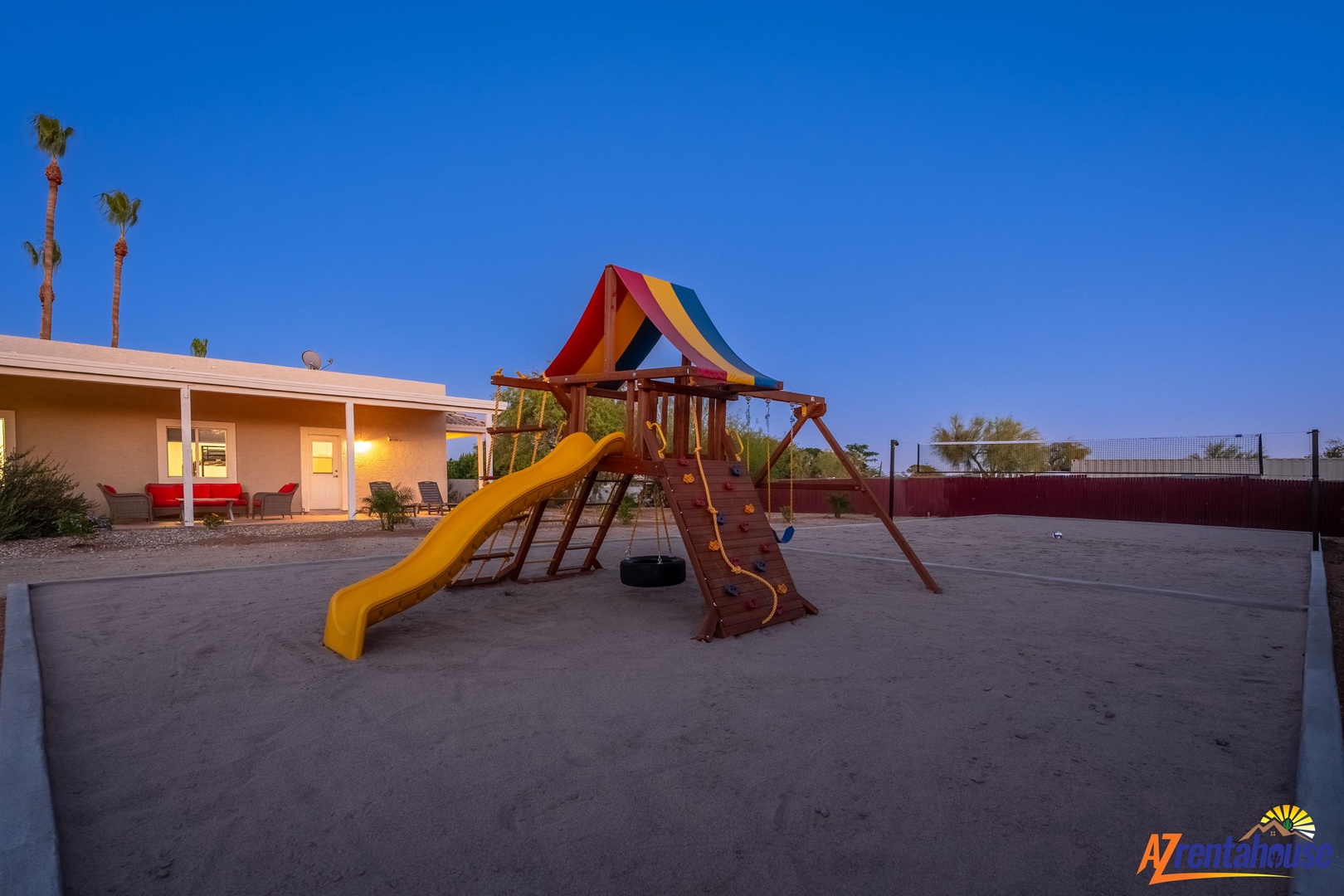 Colorful playground with slide and swings set against a clear desert sky, providing fun outdoor entertainment for families.