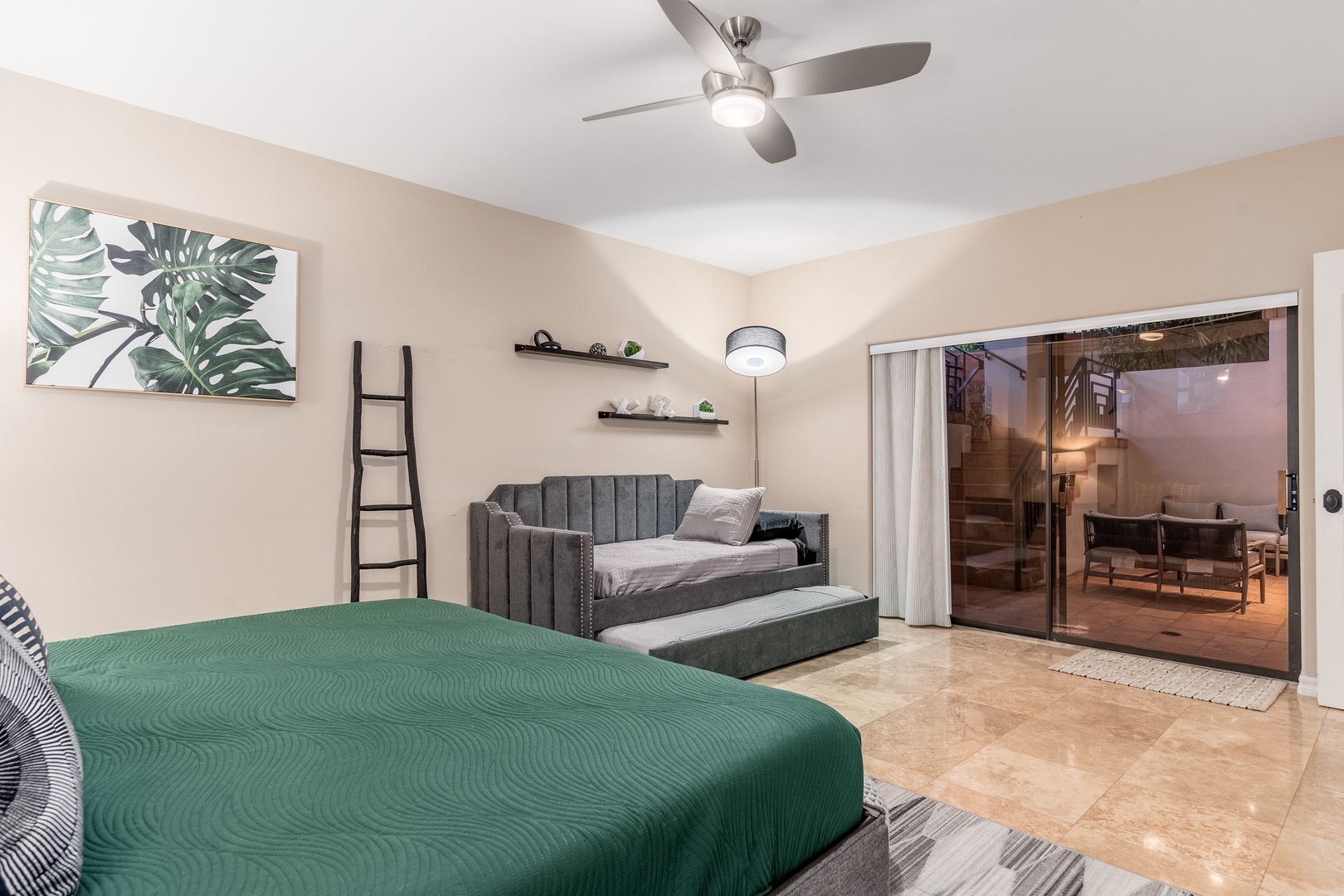 Your spacious bedroom features a plush main bed and a versatile daybed with trundle, opening to a private outdoor patio where you can enjoy your morning coffee or unwind under the stars.