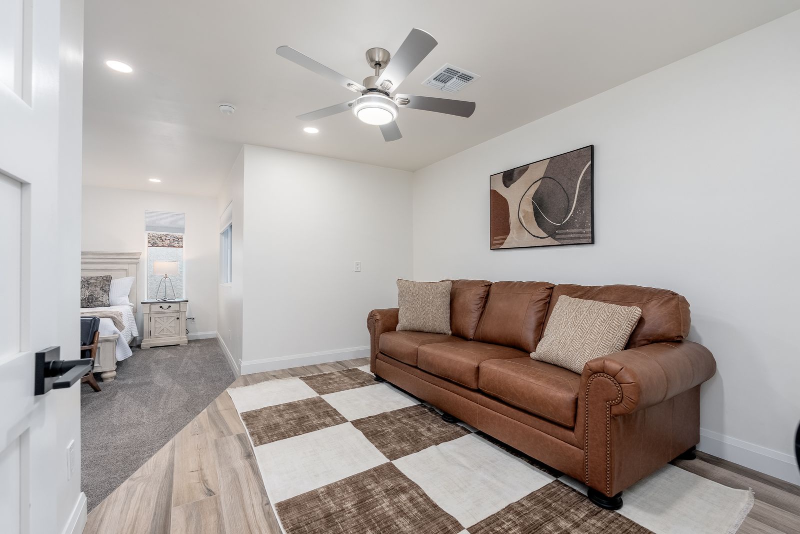 Unwind in your inviting living space with a plush leather sofa and modern ceiling fan to keep you cool after exploring the area.