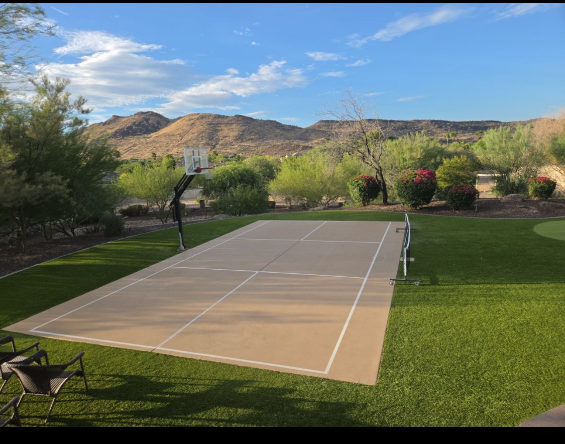 Private tennis court set against desert mountains and lush landscaping, offering active recreation in a scenic outdoor setting.