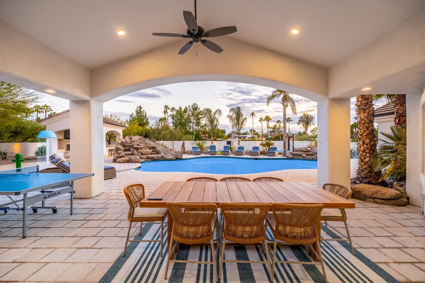 Your private poolside paradise awaits under this charming covered patio, where palm trees sway and sunshine invites endless hours of laughter, games, and outdoor dining with loved ones.