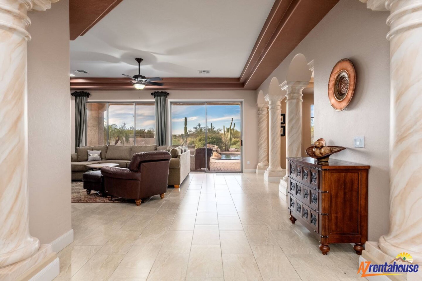Sink into plush seating and admire desert views through floor-to-ceiling windows in this elegant living space with stunning architectural details.