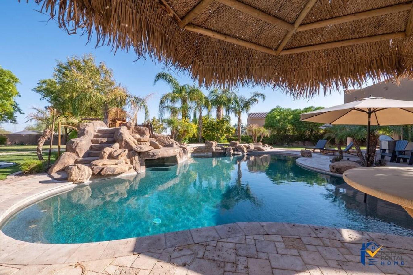 Relax under your private thatched cabana beside the sparkling pool, where cascading stone waterfalls create a tropical paradise perfect for unwinding.