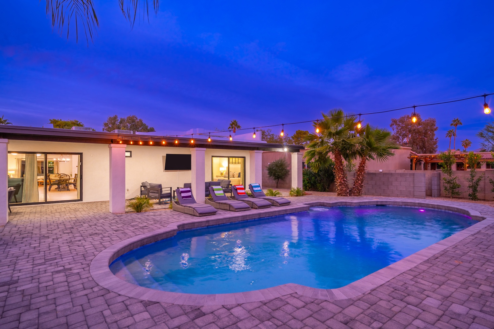 Unwind under the string lights by your private pool after sunset. The glowing water and desert palms set the stage for unforgettable evenings in your tropical escape.