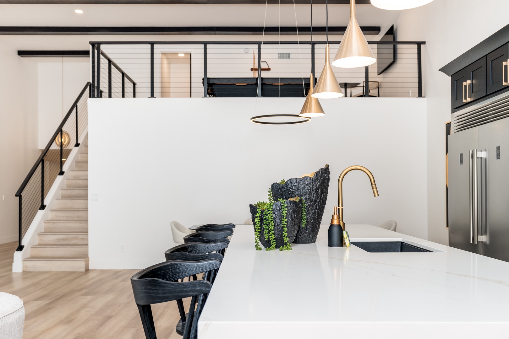 Step into a sleek, modern kitchen where every detail invites you to unwind. Bright pendants illuminate a pristine island, perfect for morning coffee or gathering with loved ones in your stylish retreat.