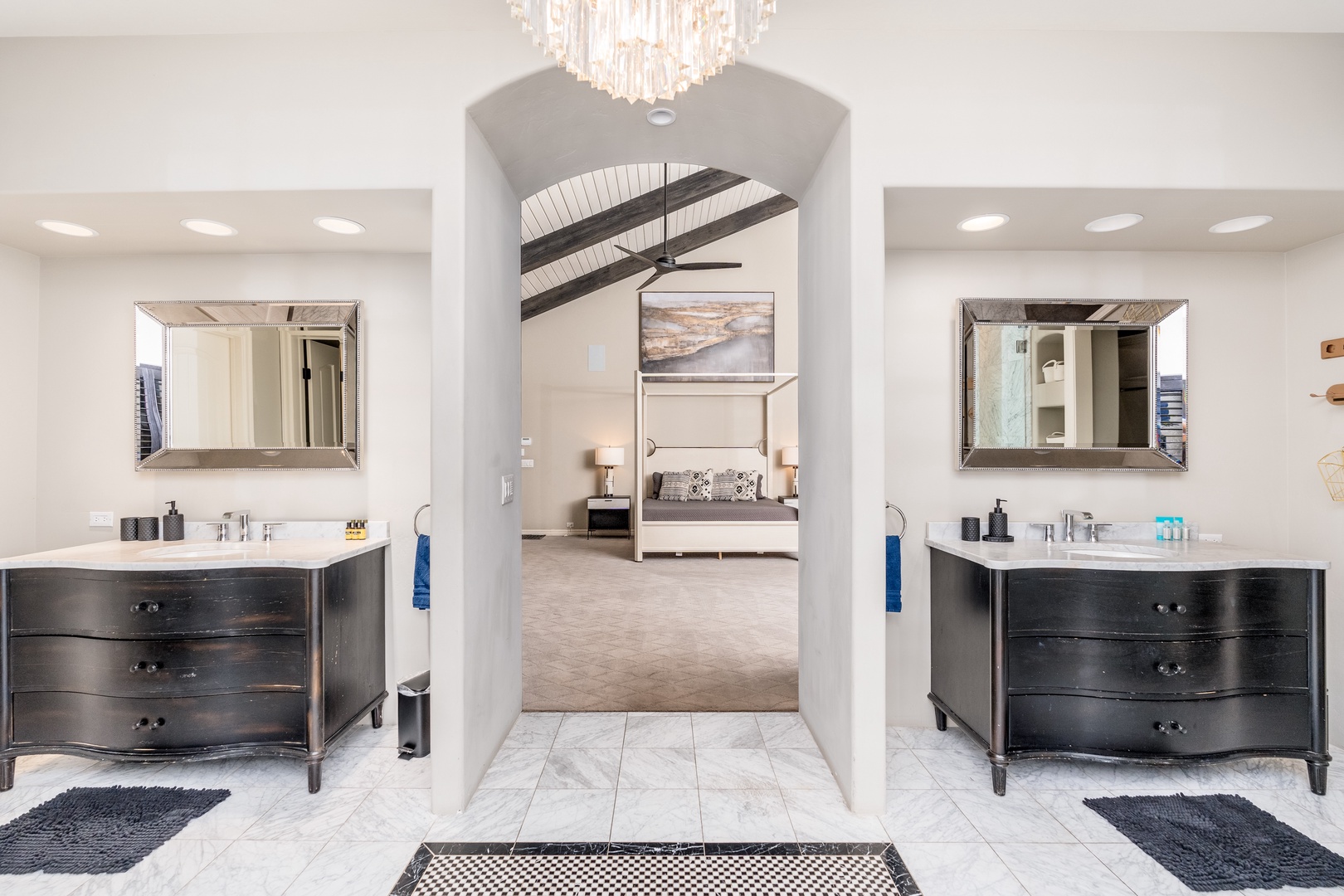 Step into your private ensuite with dual vanities, elegant mirrors, and a serene archway framing the spacious bedroom beyond—your personal sanctuary awaits.