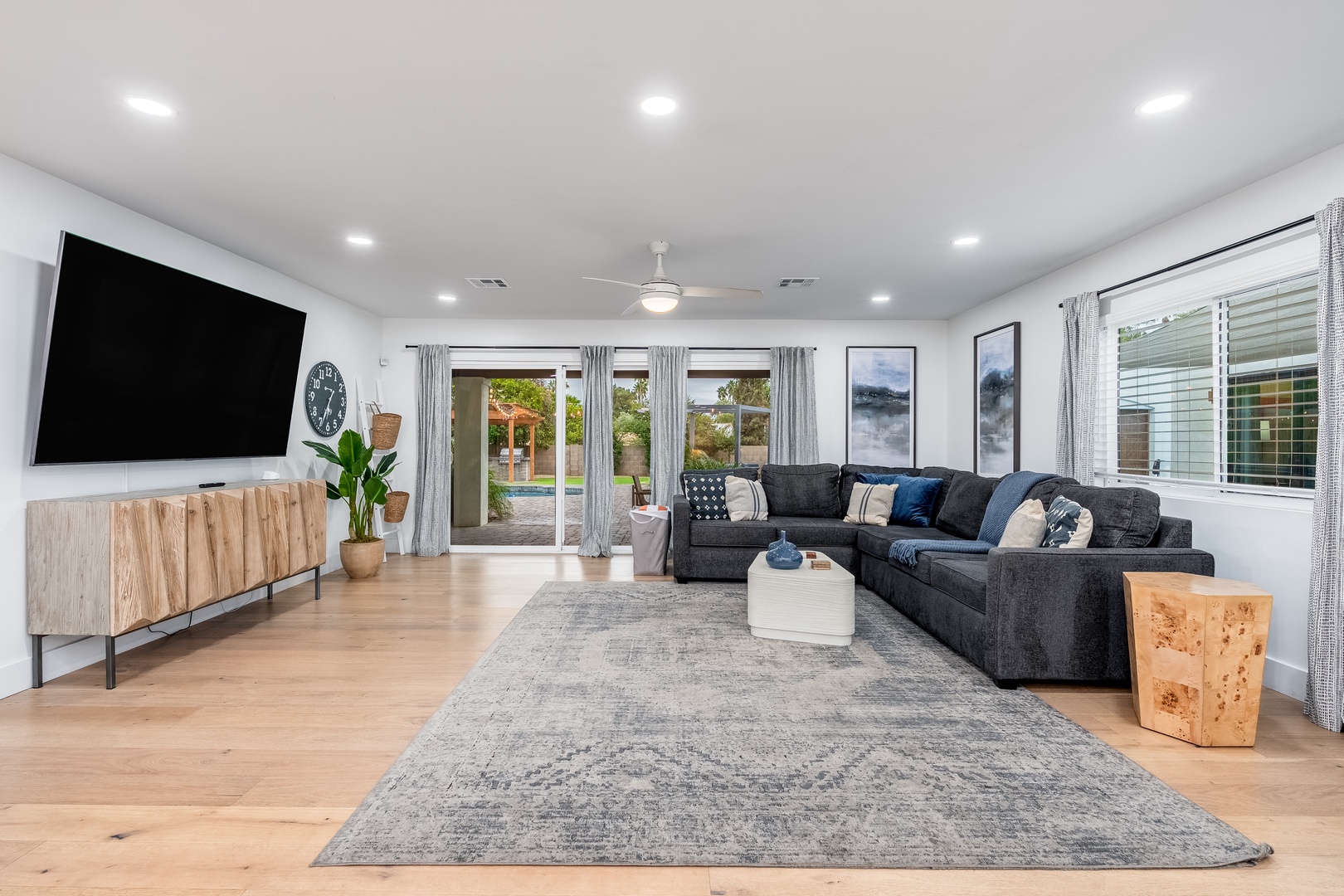Unwind on plush seating while natural light floods through patio doors, framing views of your private outdoor oasis. Perfect for movie nights or gathering with loved ones.