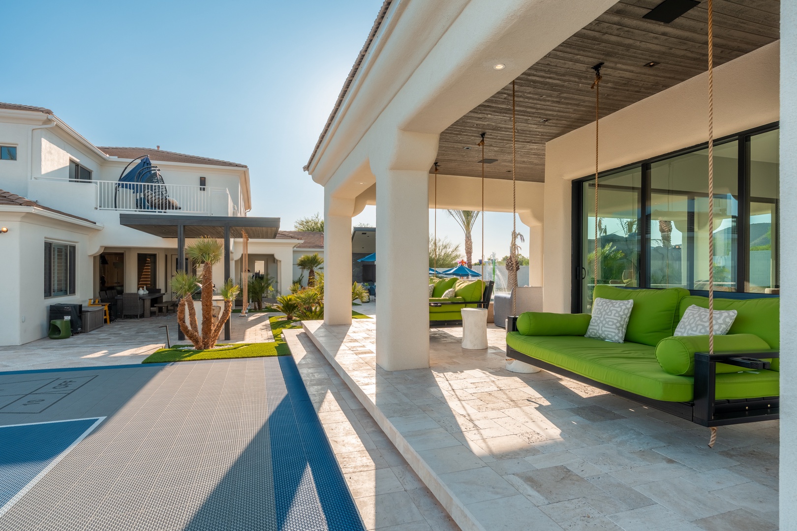 Unwind in your covered outdoor lounge with stylish swing seating and direct pool access. The shaded patio offers a perfect retreat for sunny afternoons, blending comfort with open-air relaxation.