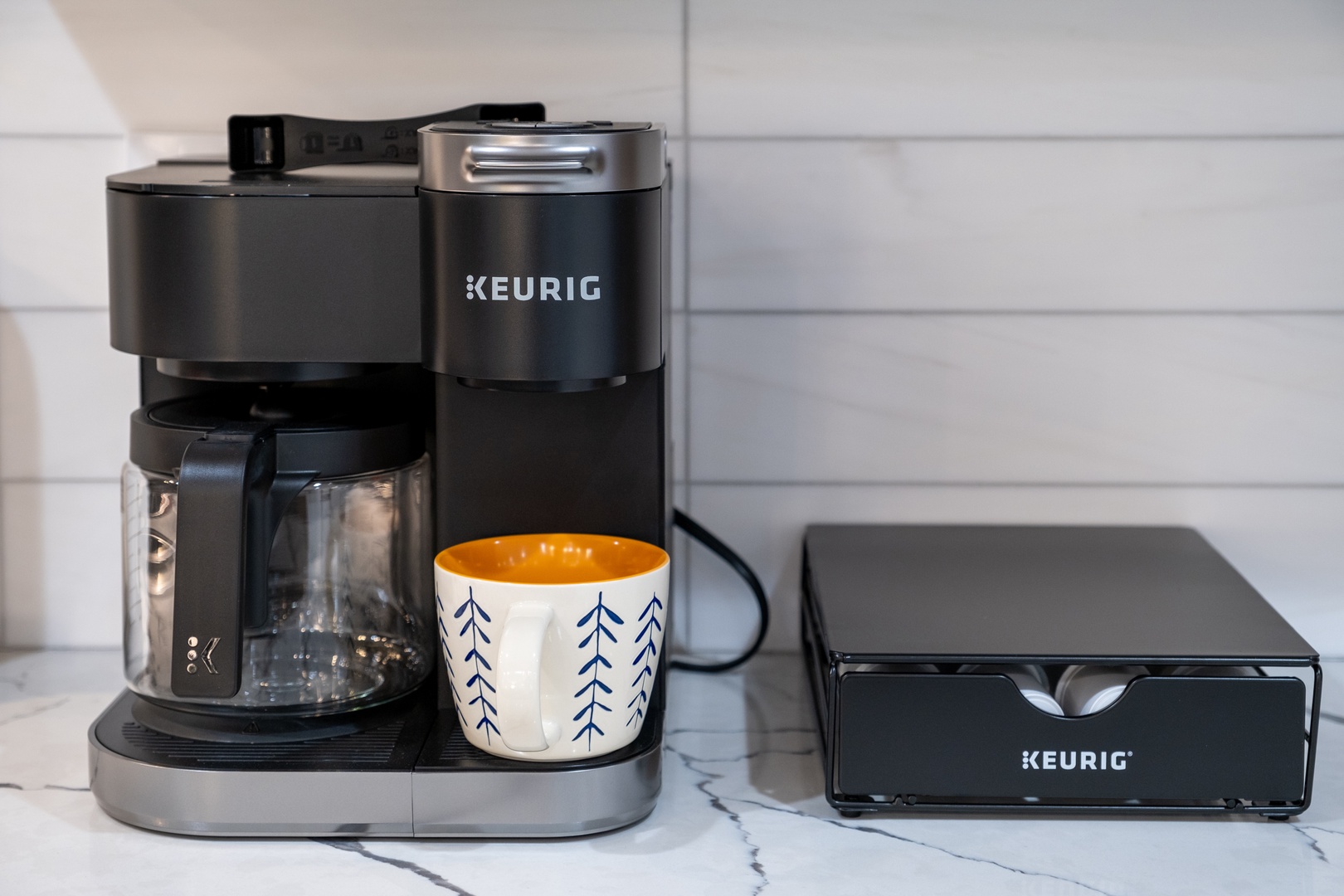 Your morning coffee awaits with this convenient Keurig setup, complete with fresh pods and a cheerful mug ready for that first delicious sip.