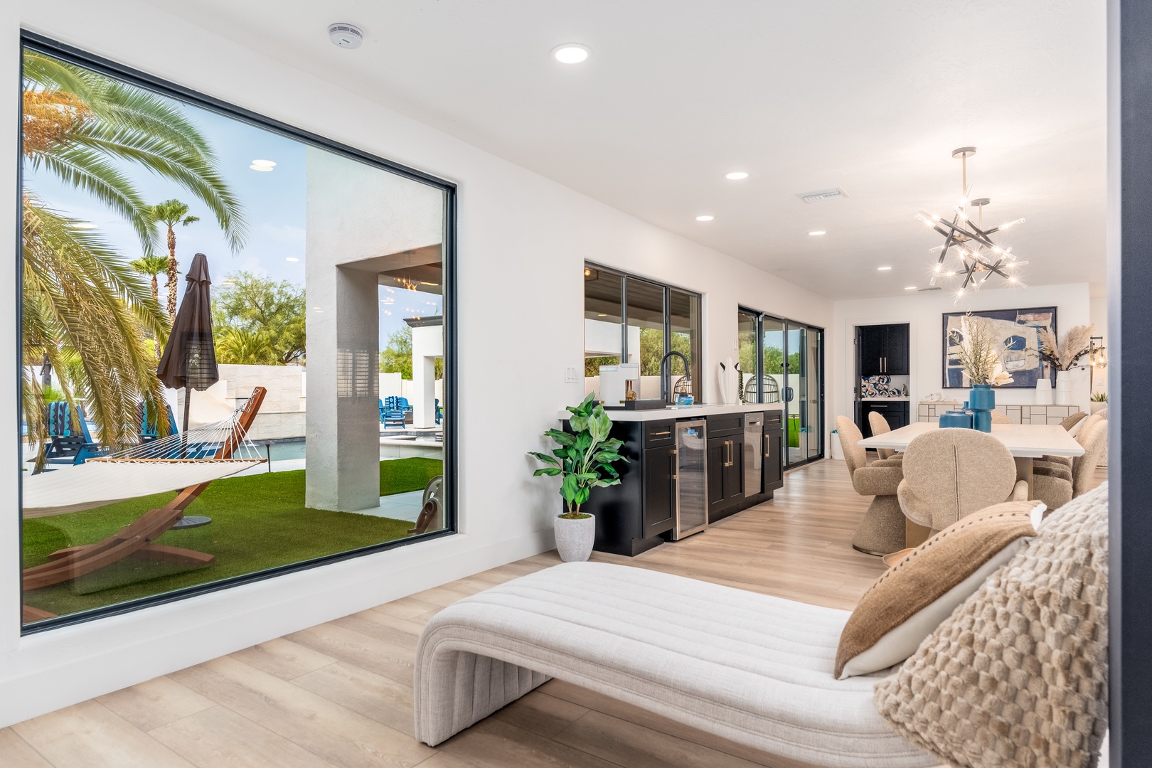 Unwind in your bright, open living space where floor-to-ceiling windows frame your private pool oasis, blending modern elegance with seamless indoor-outdoor living.