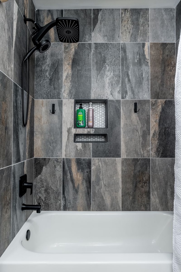 Soak away your travel stress in this sleek tub-shower combo. Enjoy the modern rainfall showerhead and handheld option, plus convenient built-in niches for your toiletries.