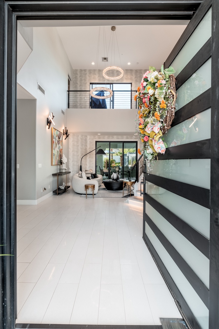 A stunning two-story foyer welcomes you with soaring ceilings, modern art, and elegant seating—your luxurious escape begins the moment you arrive.