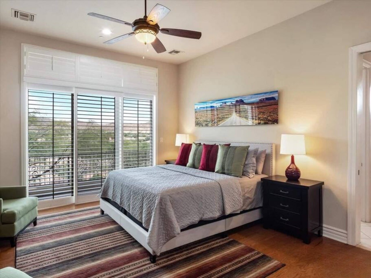 Unwind in your serene bedroom where thoughtful design meets comfort. Enjoy restful sleep beneath the gentle ceiling fan, wake to natural light through plantation shutters, and step onto your private balcony to start each morning refreshed.