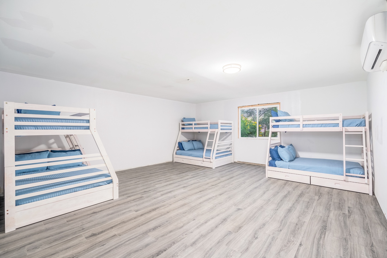 Your group's haven awaits—bright and airy sleeping quarters with crisp coastal bedding and room for everyone to rest comfortably after your adventures.