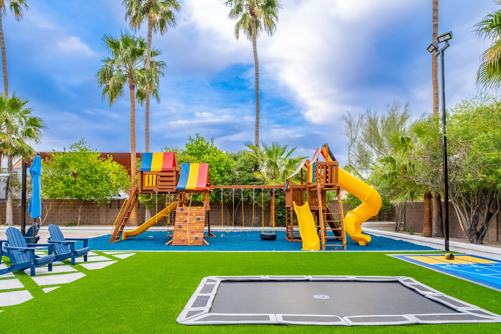 Kids will love the colorful playground, in-ground trampoline, and splash pad—all surrounded by lush palms, vibrant landscaping, and plenty of room to play in this private backyard oasis.
