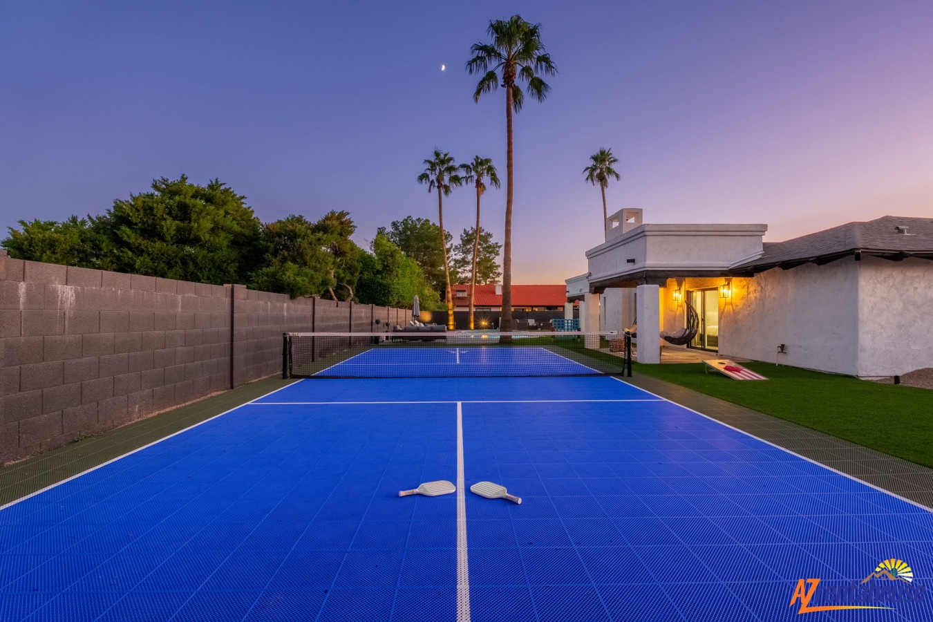 A private tennis court awaits your competitive spirit beneath swaying palms and twilight skies.